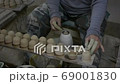hands working clay on potter's wheel, Lampang in Thailand 69001830
