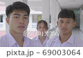 Slow motion of Asian students in a white uniform are  wearing white masks during the Coronavirus 2019 (Covid-19) epidemic. 69003064
