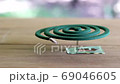 Green mosquito repellent burning and white smoke on wooden table with green blur light. 69046605