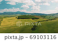 Beautiful and miraculous colors of green spring panorama landscape of Tuscany, Italy. Sunny morning near Pienza. Aerial view  69103116