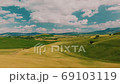 Beautiful and miraculous colors of green spring panorama landscape of Tuscany, Italy. Sunny morning near Pienza. Aerial view  69103119