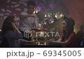 the waiter serves 2 girls clients in night cafe 69345005
