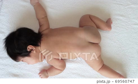 うつ伏せになっている生後2ヶ月の裸の赤ちゃんの全身の動画素材 [69560747]