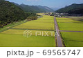 A tractor that runs on a farm road. 69565747