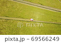 Aerial view of a large combine harvesting rice. 69566249