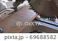 cutting a chipboard plate with circular saw 69688582