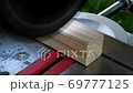 Footage of a circular saw that sawing through a piece of wood 69777125