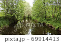 Beautiful landscape with summer river with many trees and green brushwood on the banks. Summer river surrounded by trees. Landscape with riwer flowing in forest 69914413