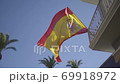 Slow motion gliding shot of Spanish flag waving in the wind with blue sky 69918972