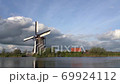 The wind mills of Kindererdijk on a cloudy day, next to the water 69924112
