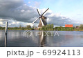 The wind mills of Kindererdijk on a cloudy day, next to the water 69924113