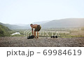 Portrait of happy smiling strong sportsman with naked torso which doing power exercises with tire from wheel on the mount with surrounded unique beautiful nature at dawn 69984619