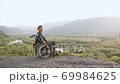 Side view of handsome confident disabled young man in wheelchair which walking on the hill to see beautiful landscapes from the height 69984625