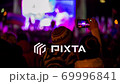 Woman Taping Concert On Smartphone In The Crowd Holding A Child 69996841