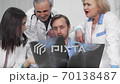 Group of doctors discussing x-ray scans of a patient together 70138487