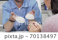 Plastic surgeon showing two breast implants to female patient 70138497