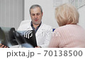 Mature male doctor examining x-ray scans of a senior female patient 70138500