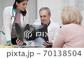 Two doctors examining x-ray scans of a senior patient 70138504