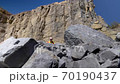 Mountain hiker. Man walks in the mountains in a yellow raincoat and a red backpack. 70190437
