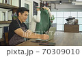 Young man cafe owner Work on laptop and chat with waitress in coffee shop. 70309010