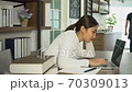 Attractive young Asian woman working on laptop in coffee shop. 70309013