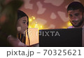 couple in love looks at laptop, laugh, communicate in night cafe 70325621