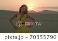 fashion blonde model in yellow clothes posing at sunset in the desert 70355796