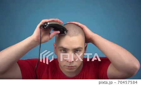 The bald young man insolently shaves his head....の動画素材 [70457584]