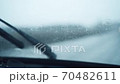 Front car windshield with rain drops on it while driving. Focusing rain drops. Driving in the rain 70482611