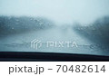 Front car windshield with rain drops on it while driving. Focusing rain drops. Driving in the rain 70482614