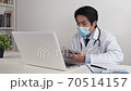 Asian Doctor Wear Face Mask Check Physical Examination Report from Tablet in Office 70514157