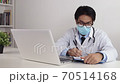 Asian Doctor Wear Glasses and Face Mask Write Patient Exam Report in Office 70514168