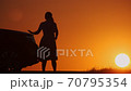 Silhouette of upset woman near broken car in evening on country deserted road. 70795354