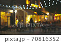 Slow motion shot of illuminated street with cafes and summer terraces. People walk along the pedestrian street of the old city and choose a place for dinner. Cozy restaurants for a romantic evening 70816352