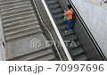 woman while climbs the metro station stairs wearing protective mask 70997696