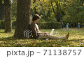 Hipster typing on laptop in the park 71138757