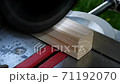 Footage of a circular saw that sawing through a piece of wood 71192070