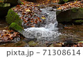 Slow motion of a river cascading peacefully down a small, scenic waterfall 71308614
