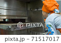 Children cooking pizza in the pizzeria, they are waiting for when it rolled out of the oven 71517017