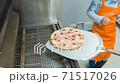 Children cooking pizza in the pizzeria, cook pulls out a pizza of the oven using a shovel 71517026