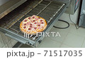 Cook pulls out a pizza of the oven using a shovel 71517035