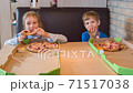 Children eat pizza in the pizzeria 71517038