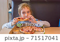 The girl eats pizza in the pizzeria 71517041