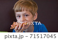 The boy eats pizza in the pizzeria 71517045