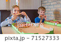 Children eat pizza in the pizzeria 71527333