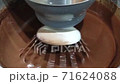 Loop video. Abstract of chocolate cake batter being mixed in an electric mixer. Extreme shallow DOF with focus on wire mixer 71624088