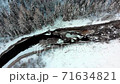 Aerial view: Flight over the winter river and forest. Snow covered trees. Winter landscape, nature, sun rays. River in ice 71634821
