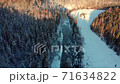 Aerial view: Flight over the winter river and forest. Snow covered trees. Winter landscape, nature, sun rays. River in ice 71634822