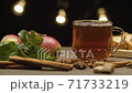 Tea in glass mug, apples and spices 71733219