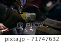 Grinding metal with a grinder. The blacksmith works with metal. Blacksmithing craft. 71747632